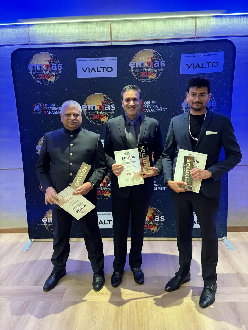 Eashan Gupta with two IKAN colleagues at the FEM APAC EMMA awards in Singapore, each holding the award