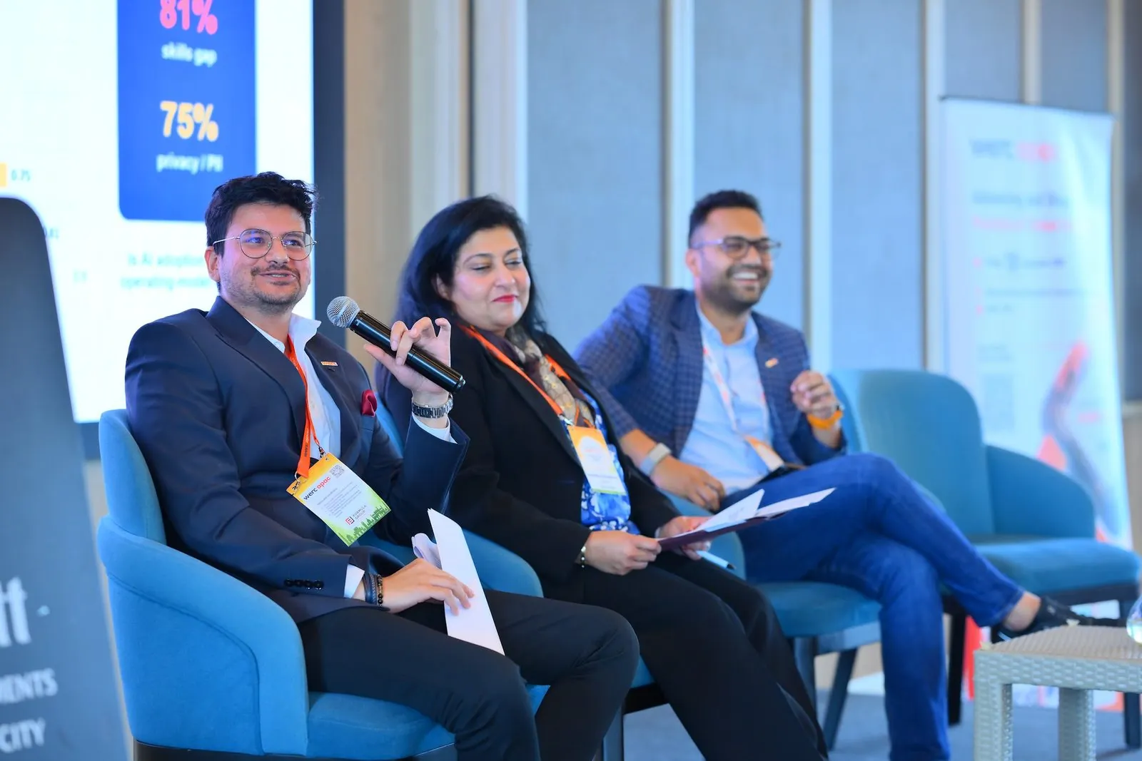 Eashan Gupta speaking on the AI panel at an industry conference in Bengaluru, the pulse survey results on the screen behind him