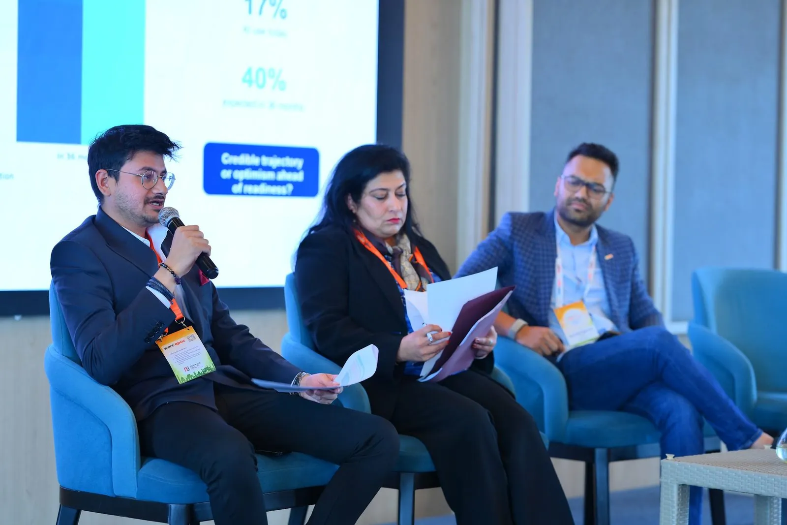 Eashan Gupta speaking on the AI panel, the results of a pulse survey on the screen behind him