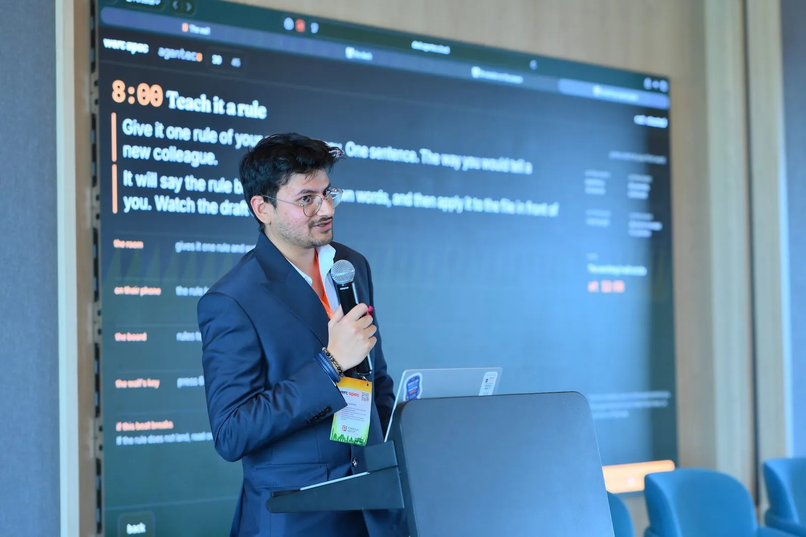 Eashan Gupta at a screen, showing a room of mobility leaders how to write one rule for an AI agent